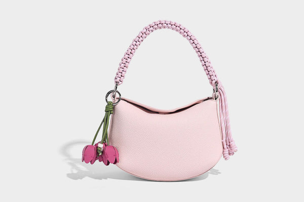 Small crescent half-moon bag in pebbled leather-look finish with braided top handle, silver-tone ring hardware, and, detail