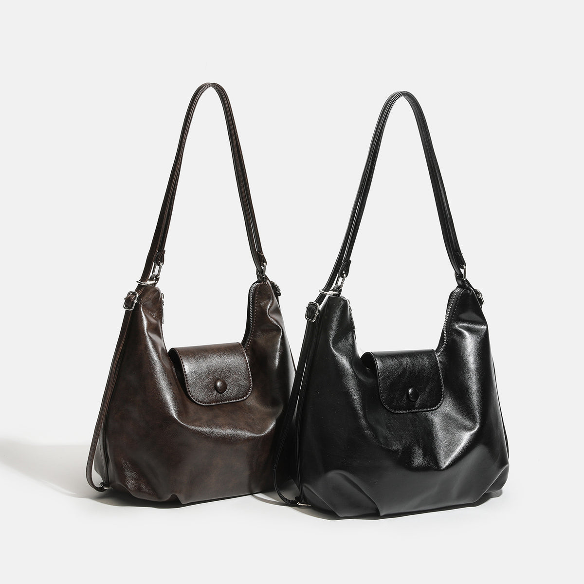 Lässig fallende Hobo-Schultertasche in glänzender Lederoptik mit vorderer Klappentasche und Druckknopf sowie silberfarbenen Metallbeschlägen, Detailansicht 2