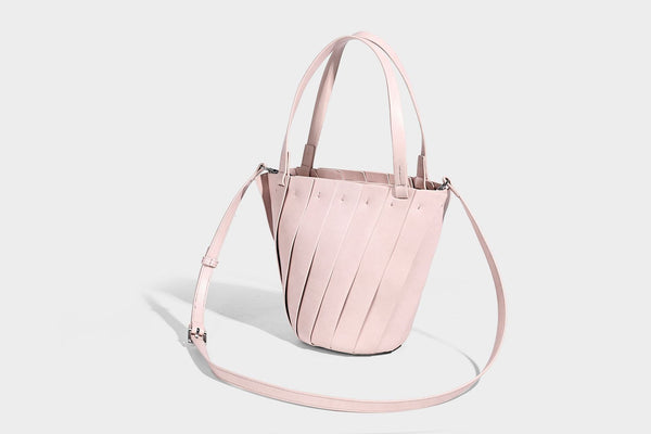 Structured bucket tote bag with vertical panel exterior, dual top handles, and detachable shoulder strap in tan leather-look