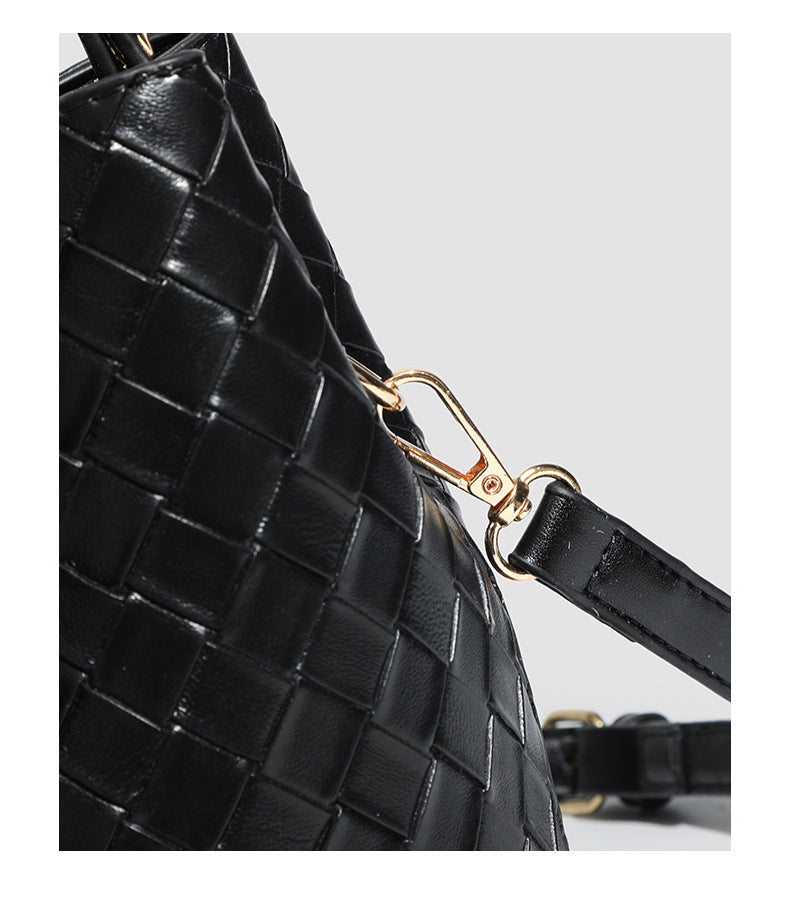 Black woven leather-look bucket bag with gold-tone clip closure, top handle, detachable shoulder strap, and knit bunny charm