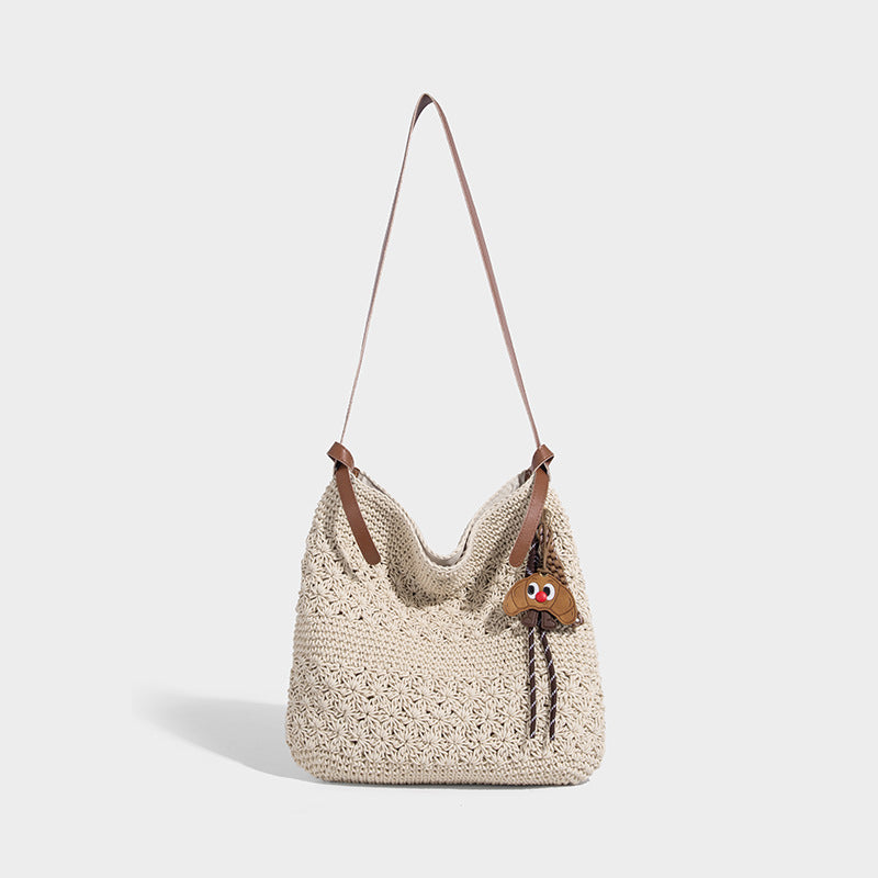 Slouchy woven crochet shoulder bag with cognac leather-look adjustable strap and snap-top closure, front view
