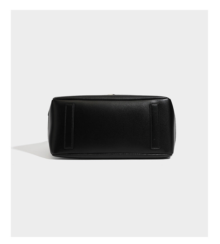 Schwarze Tote-Bag aus genarbtem Material in Lederoptik mit kürbisförmigen Beschlägen in Goldoptik, zwei Henkeln und abnehmbarem Umhängeriemen, Detailansicht