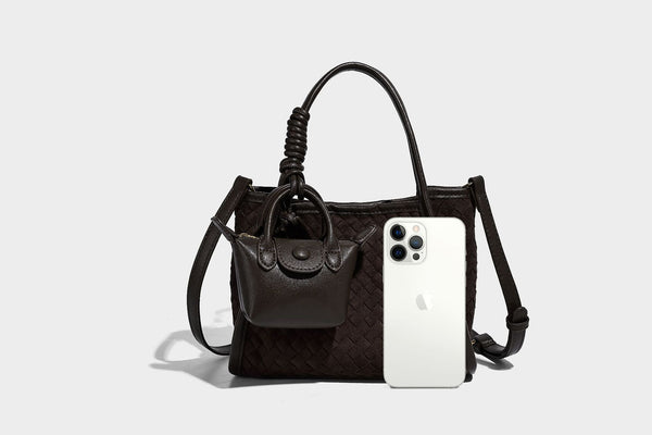 Strukturierte Tote-Bag mit gewebter Oberfläche, befestigtem Mini-Charm-Täschchen, geknoteten Tragegriffen und abnehmbarem Schulterriemen, Detailansicht