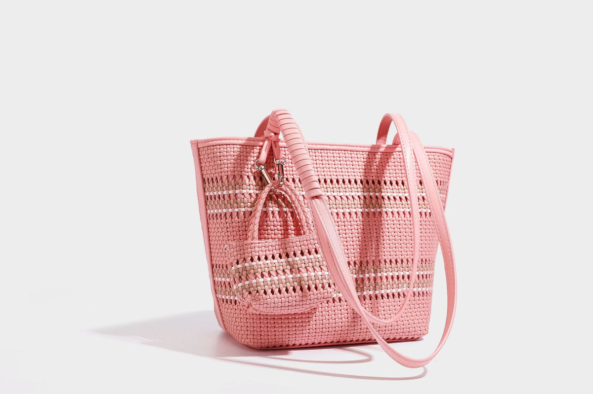 Large structured woven tote bag with striped basket-weave finish, long shoulder straps, and detachable mini pouch charm