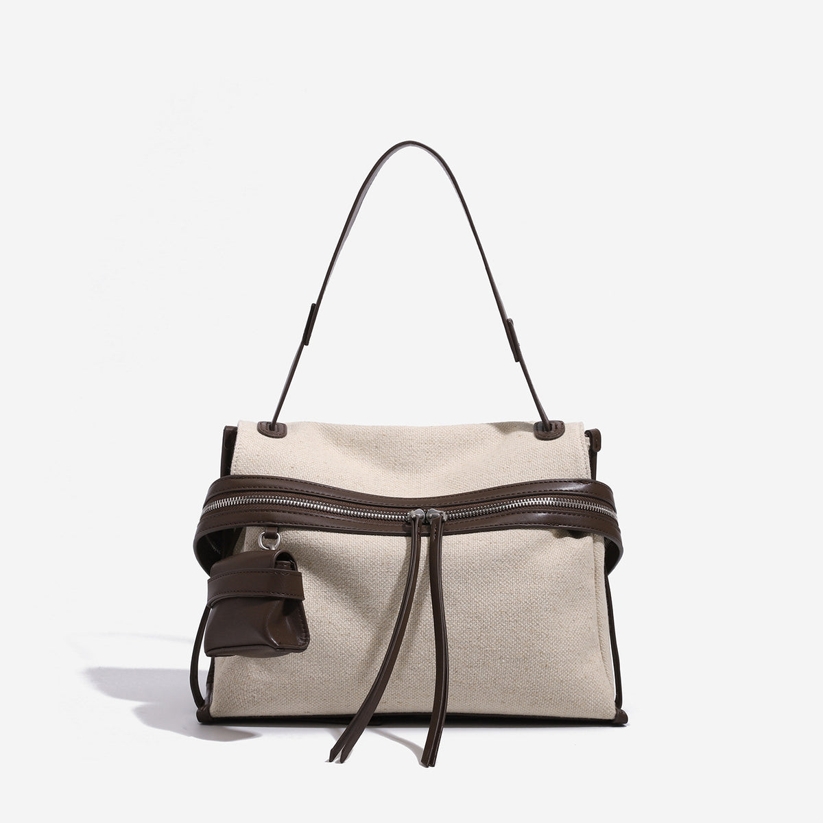 Cream canvas zip-top shoulder bag with cognac leather-look trim, dual zipper, attached mini pouch, and tassel strap ties