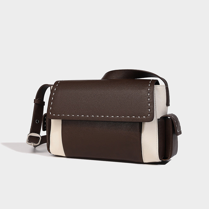 Structured flap crossbody bag in dark brown and cream color-block with white contrast stitching, adjustable shoulder strap