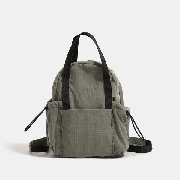 Mini rounded convertible backpack handbag in matte ripstop fabric with dual top handles, adjustable straps, and side, detail