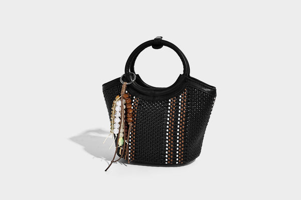 Kleine strukturierte Beuteltasche aus geflochtenem Material mit rundem Tragegriff in Lederoptik, silberfarbenen Beschlägen und perlenbesetztem Quastenanhänger, Detail