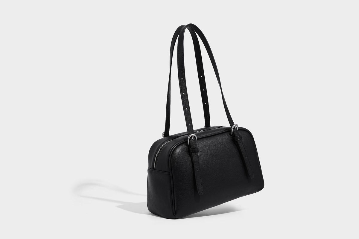 Structured dome-shaped shoulder bag with leather-look finish, top zipper closure, dual adjustable slim straps, and, detail