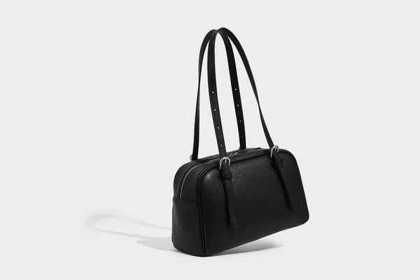 Structured dome-shaped shoulder bag with leather-look finish, top zipper closure, dual adjustable slim straps, and, detail