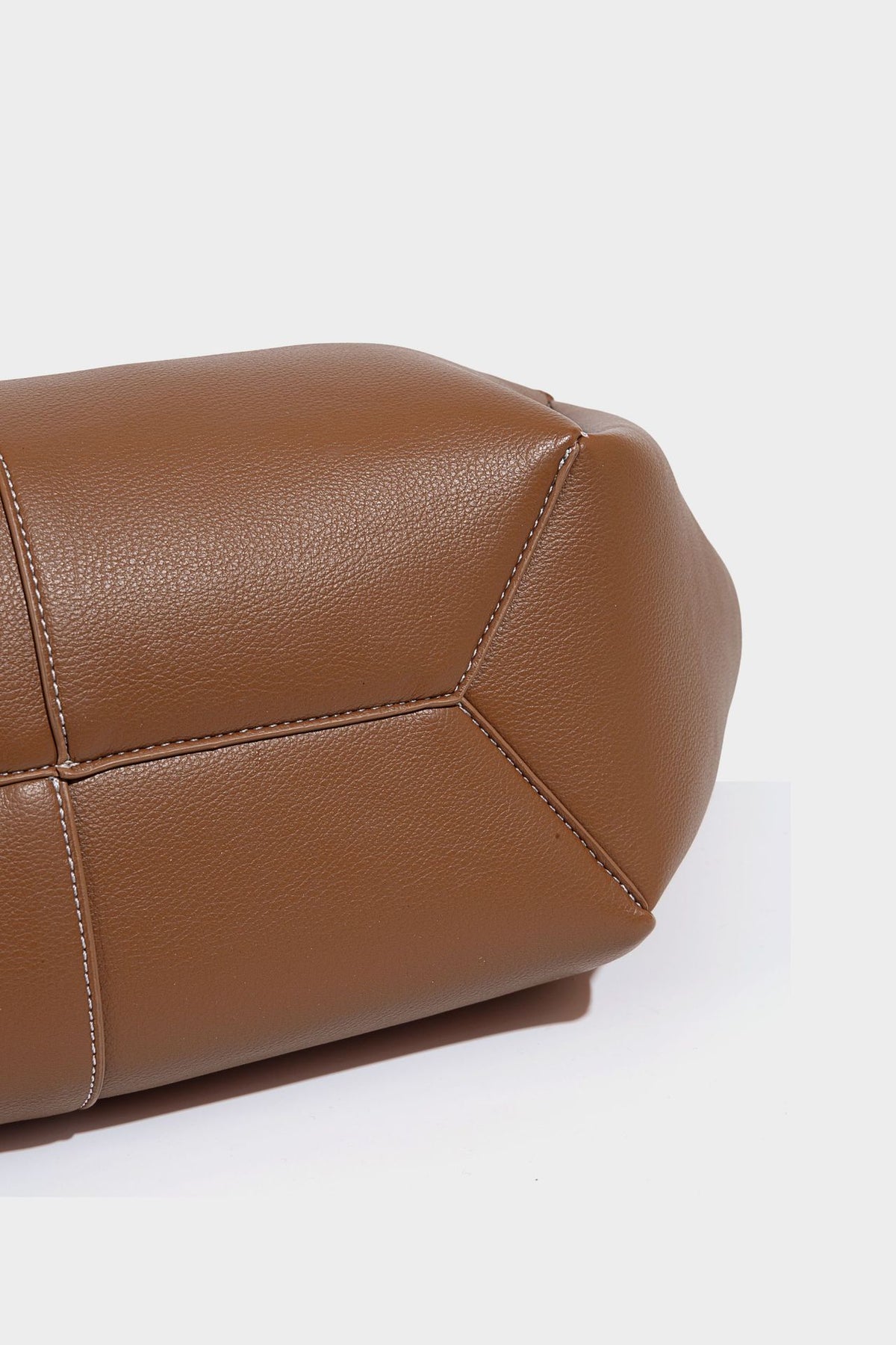Große, formstabile trapezförmige Tote-Bag aus braunem Lederimitat mit genarbter Oberfläche, zwei Tragegriffen und seitlichen Bindebändern, Detail
