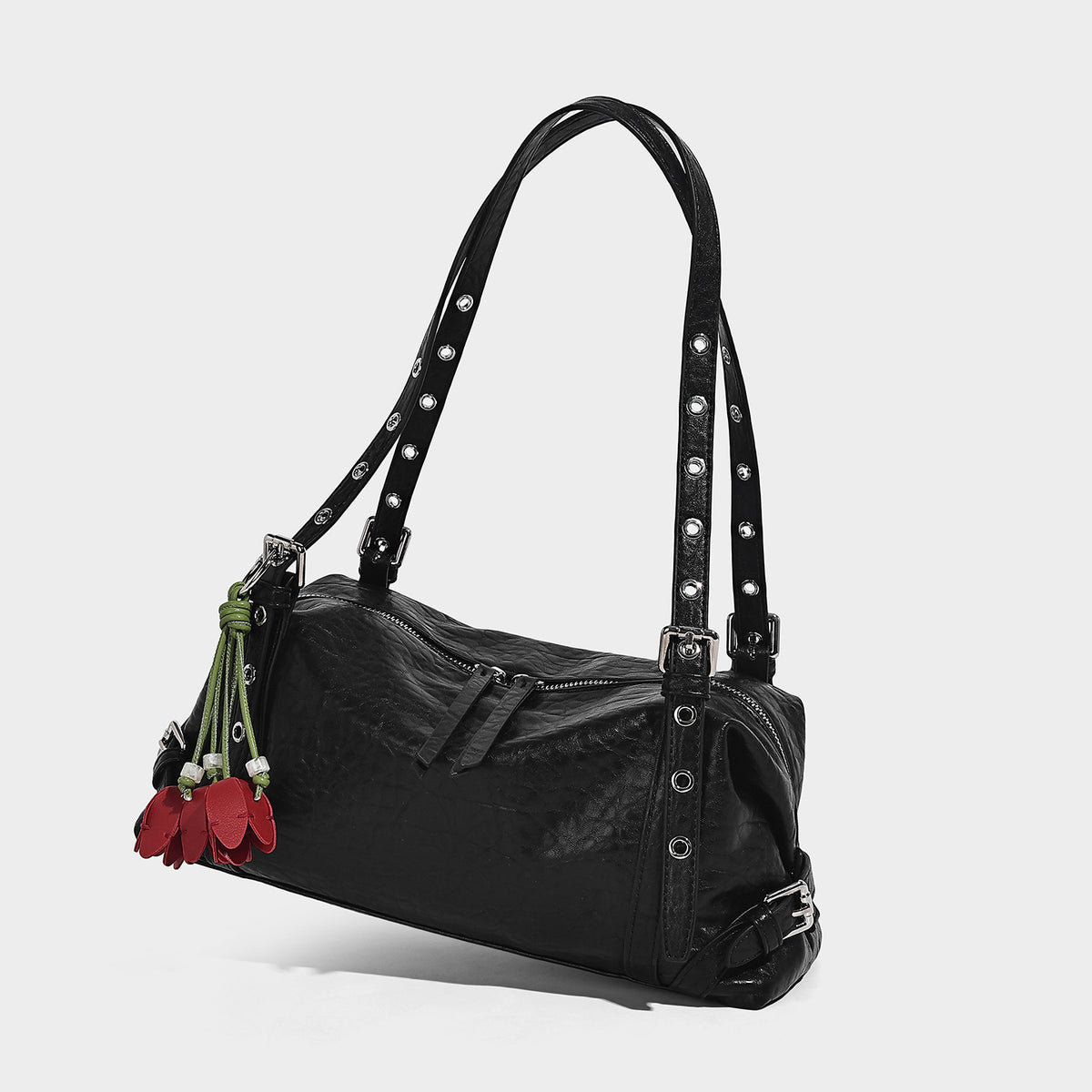 Pale yellow leather-look barrel bag with silver grommet-studded shoulder straps, top zip closure, and pink tulip floral