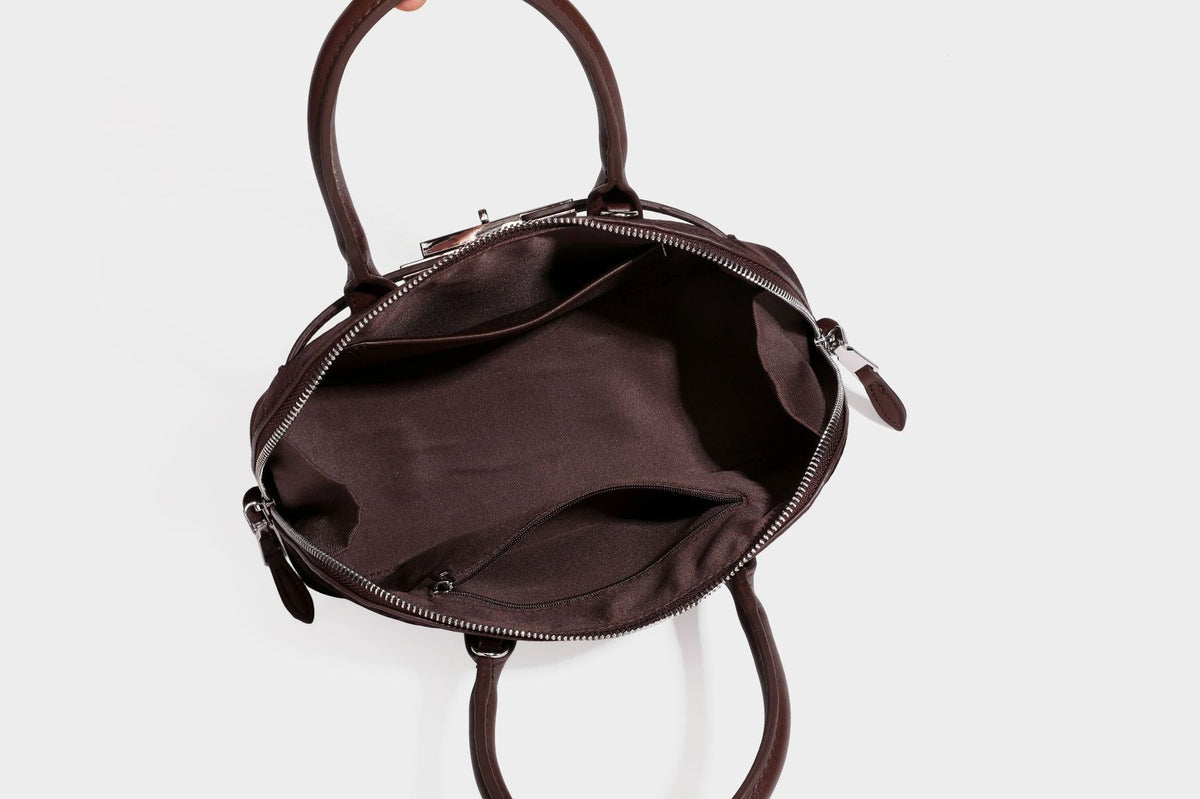 Small structured satchel bag in dark brown velvet-like textured finish with leather-look trim, silver-tone turn-lock bar