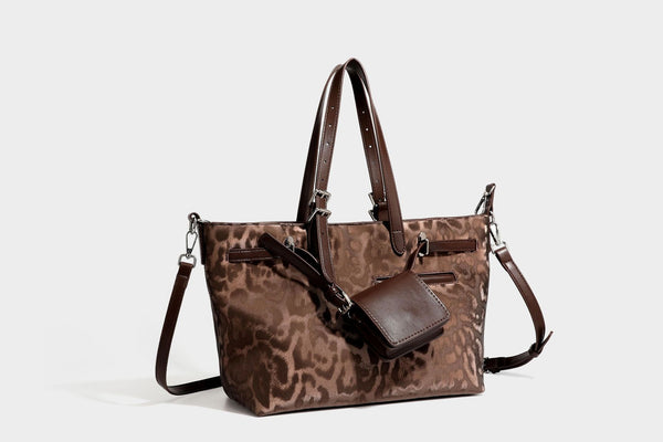 Glossy leopard-print tote bag with leather-look dark trim, dual top handles, detachable shoulder strap, and attached front