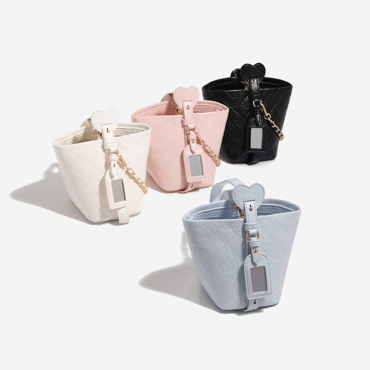 Small diamond-quilted bucket bag with gold-tone chain accent, heart strap detail, hanging tag, and matching zip coin pouch