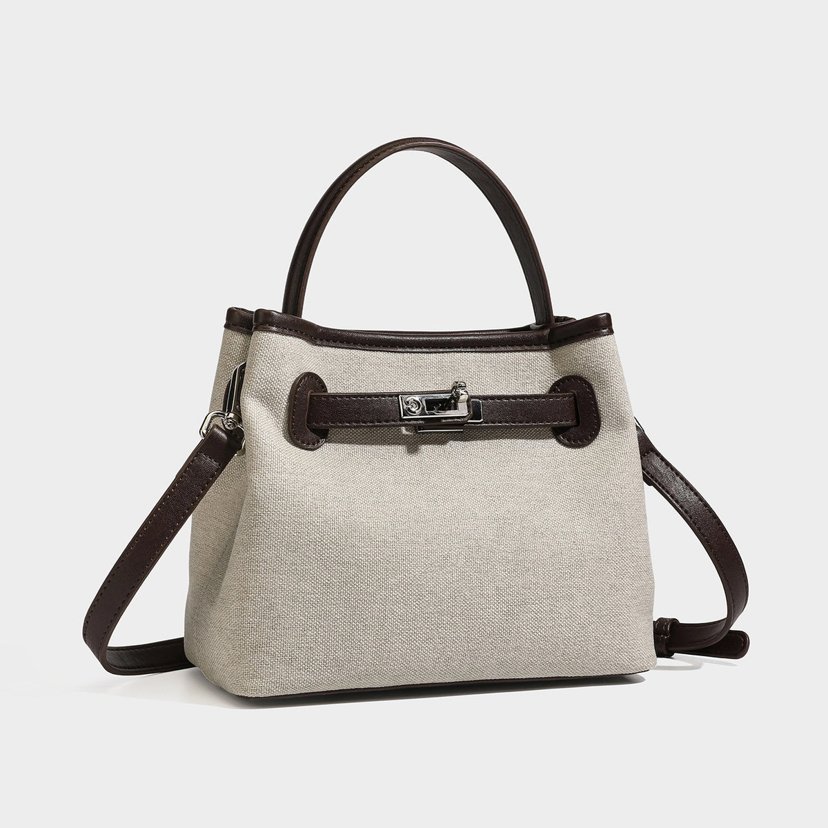 Small structured beige canvas top-handle bag with dark brown leather-look trim, silver turn-lock hardware, and detachable