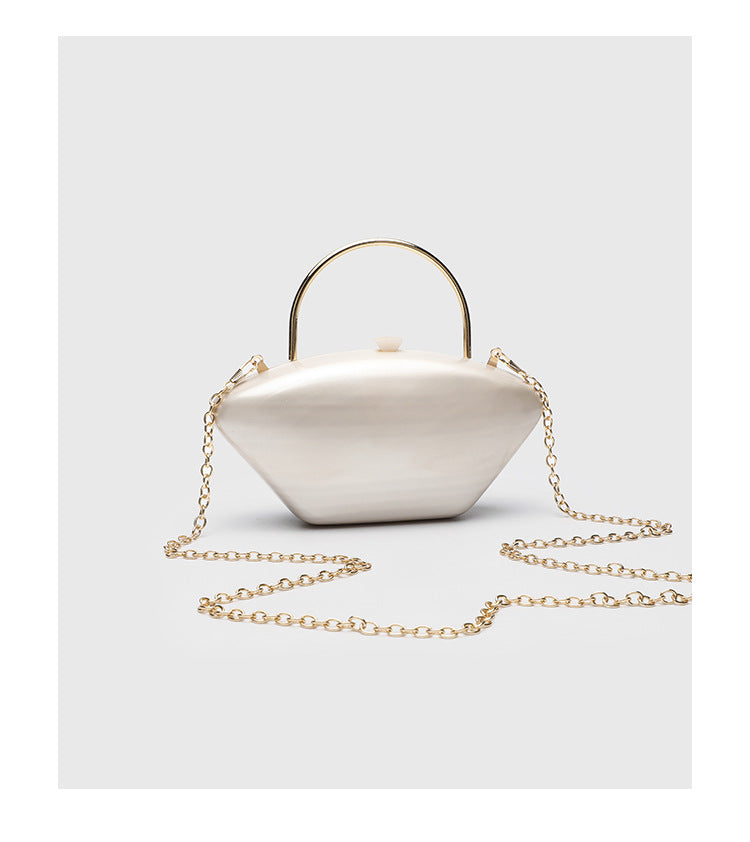Shell-shaped pearlescent top-handle clutch bag with arched gold-tone metal handle and gold chain strap, detail view 13