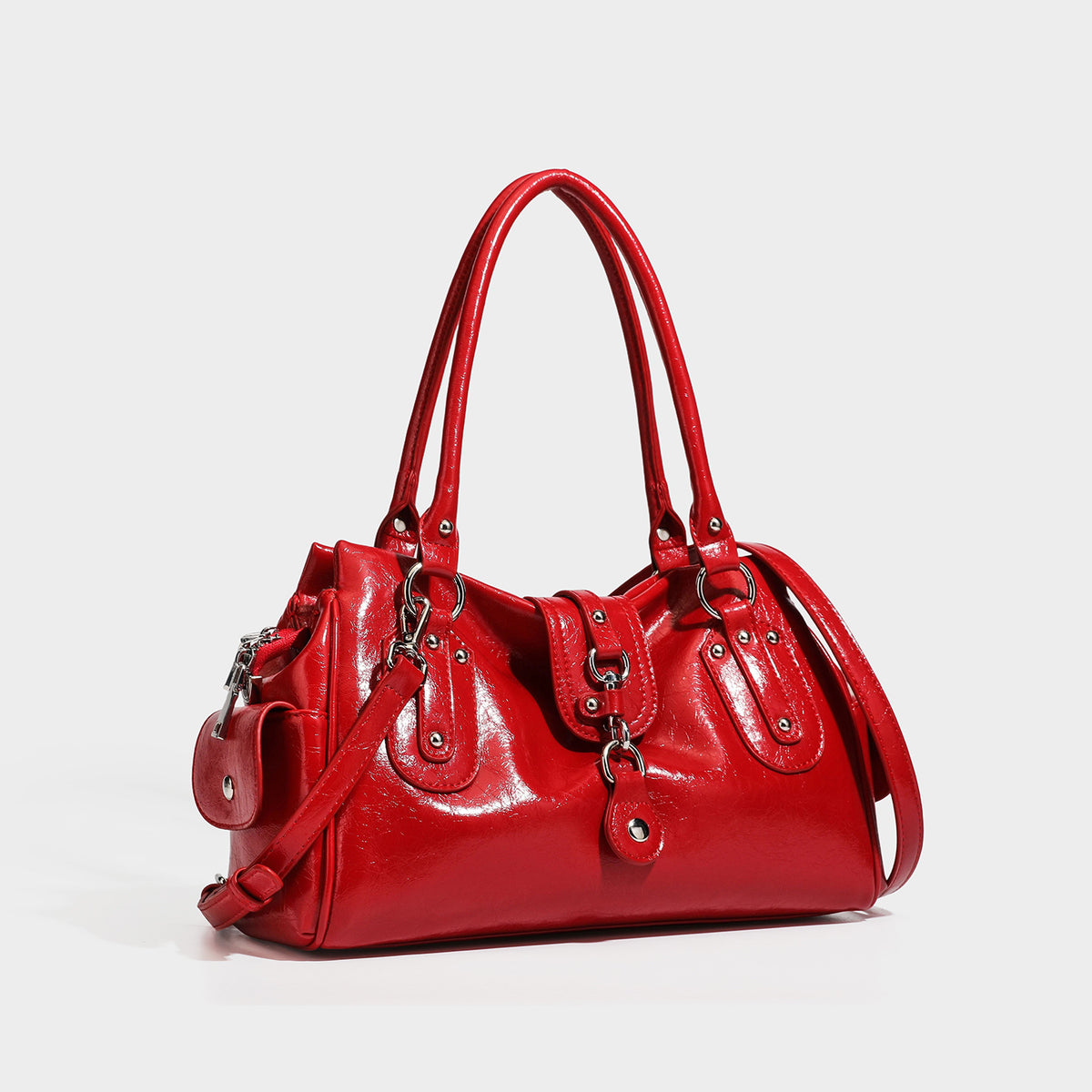 Glänzende, geknautschte Henkeltasche im Barrel-Stil mit zwei Henkeln oben, vorderem Klappen-Riemen-Element, Ring- und Nietenbeschlägen sowie abnehmbarem