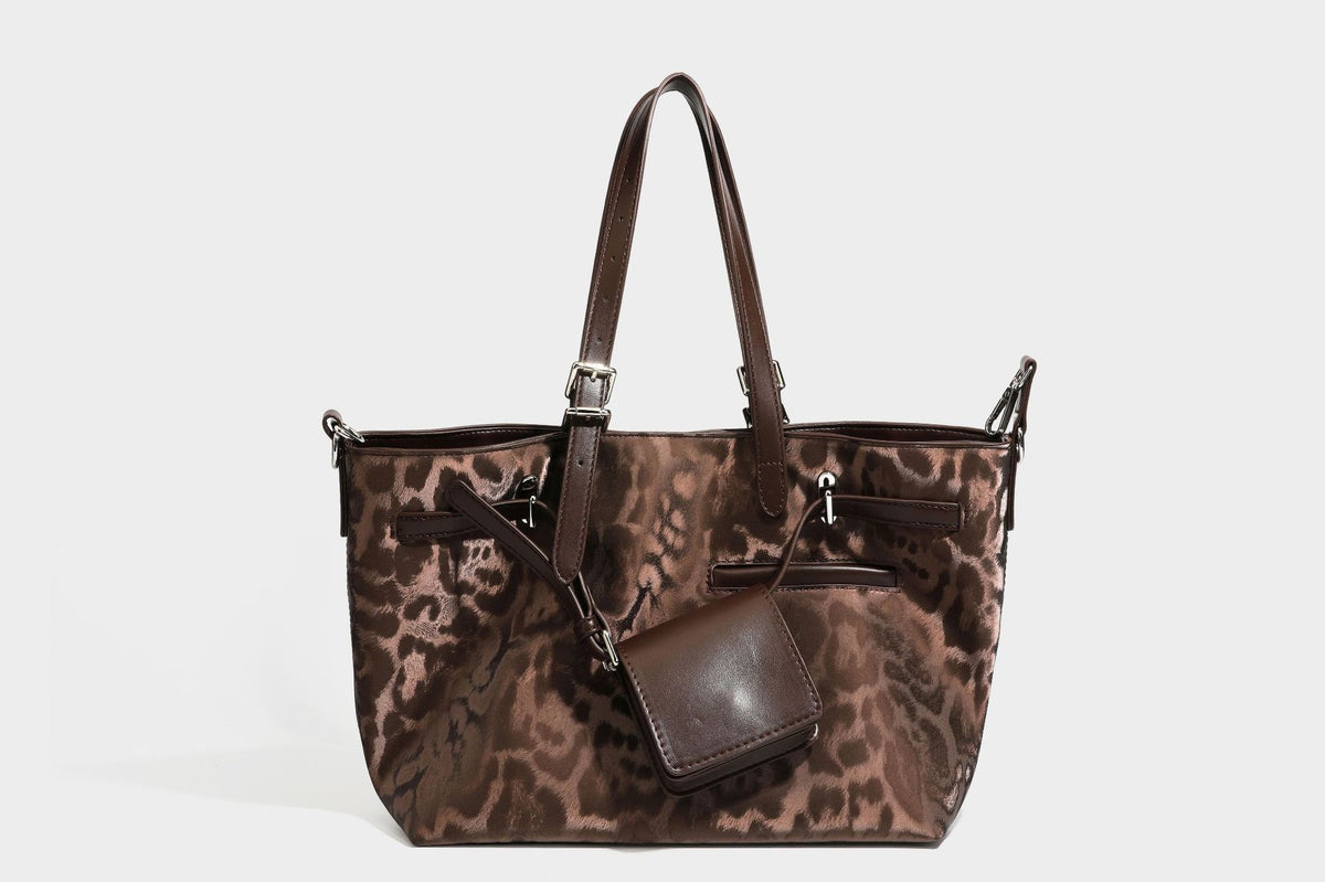 Glossy leopard-print tote bag with leather-look dark trim, dual top handles, detachable shoulder strap, and attached front