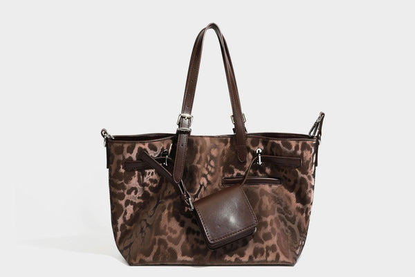 Glossy leopard-print tote bag with leather-look dark trim, dual top handles, detachable shoulder strap, and attached front