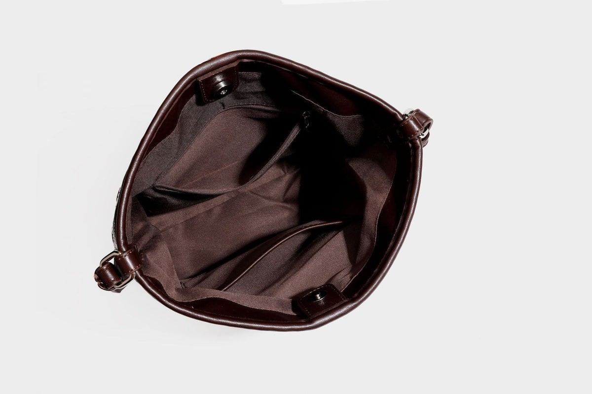 Geflochtene Schultertasche mit geometrischem Ethno-Muster, Besatz in dunkelbrauner Lederoptik, langem verstellbarem Träger und kleinem hängendem Reißverschluss