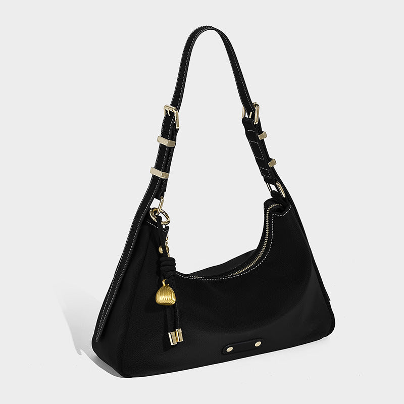 Crescent hobo shoulder bag in pebbled leather-look finish with top zipper, adjustable strap, gold-tone ring hardware, and