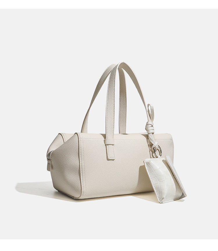 Structured pebbled leather-look top-zip barrel bag with dual handles, detachable shoulder strap, and attached croc-pattern