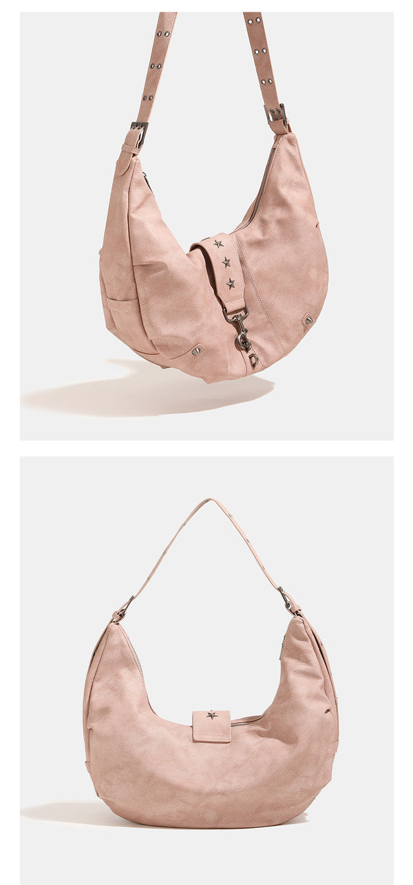 Crescent hobo shoulder bag in matte leather-look finish with star stud front panel, antique-silver hook hardware, and, detail
