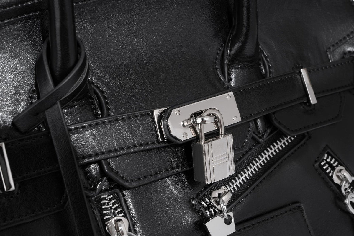 Structured black leather-look satchel bag with silver padlock hardware, front zip pockets, key charms, and top handles