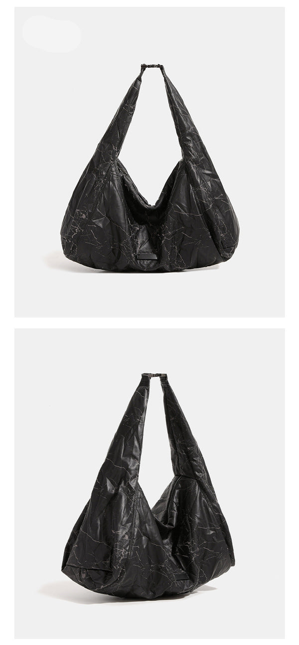 Oversized slouchy hobo shoulder bag in dark marled denim-texture fabric with top zip closure and adjustable single strap