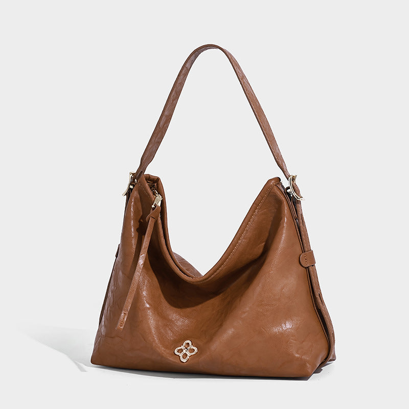 Slouchy leather-look hobo shoulder bag with gold-tone hardware and adjustable strap in brown, front view