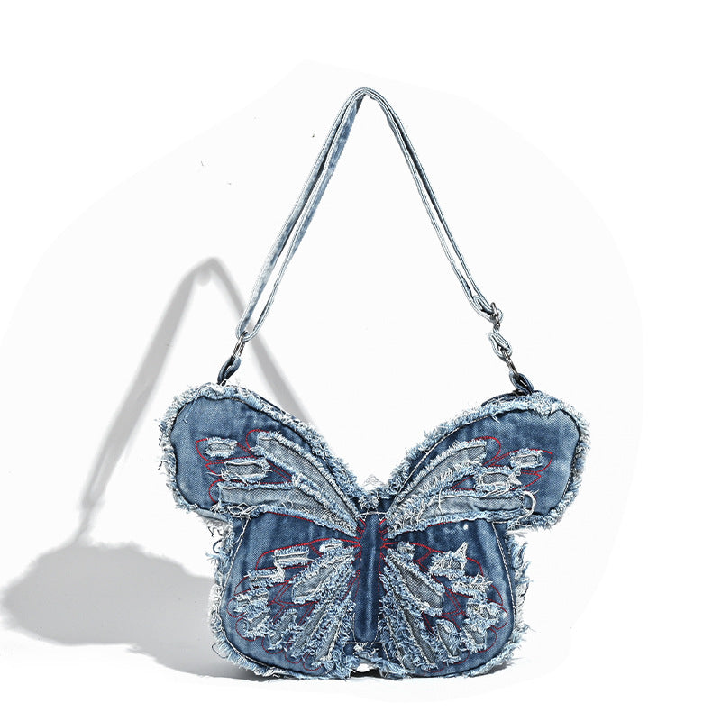Butterfly-shaped distressed denim shoulder bag with frayed raw edges and embroidered wing panels, detail view 5