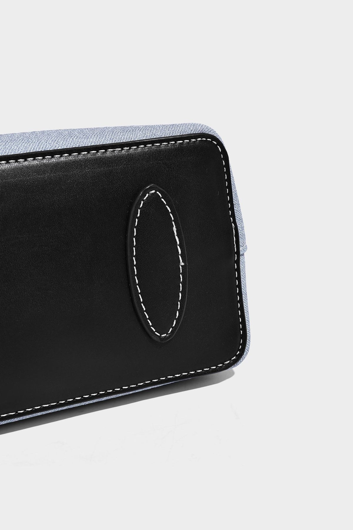 Structured light-blue denim-look tote bag with black leather-look handles, white contrast stitching, silver-tone hardware