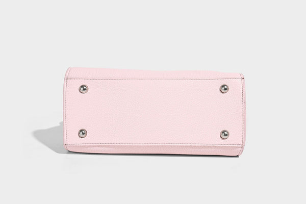 Small structured pebbled-finish shoulder bag with braided top handle, detachable crossbody strap, floral tassel charm, and