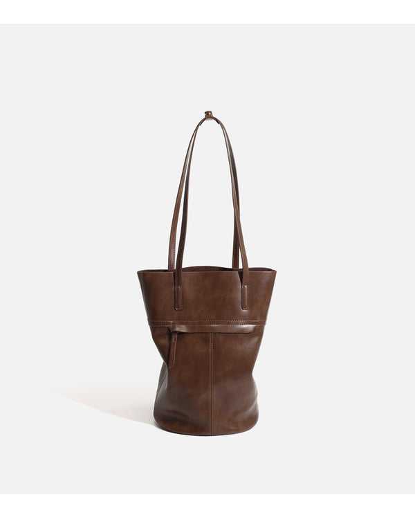 Large black smooth leather-look bucket tote bag with long shoulder straps and open top, detail view 10
