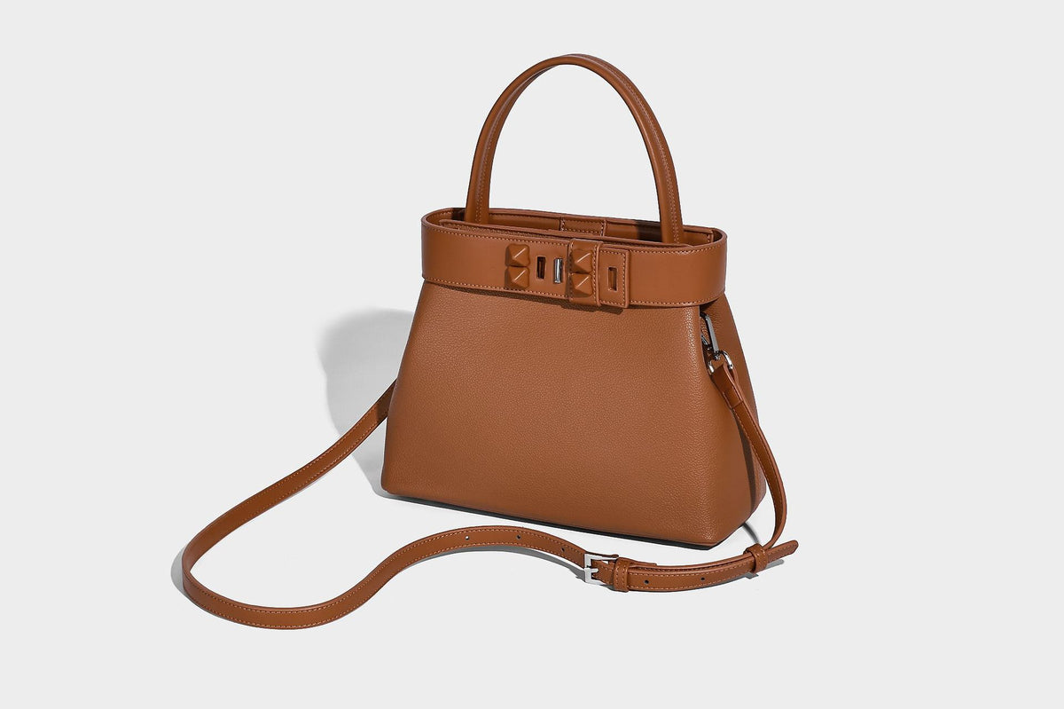 Strukturierte Trapez-Tote-Bag mit oberem Riemen mit Gürtelschnalle, genarbter Lederoptik und silberfarbenen Beschlägen, Detailansicht