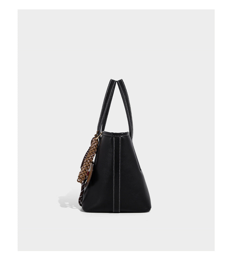 Compact structured bucket tote bag with pebbled textured finish, dual top handles, silver-tone lock hardware, and detachable