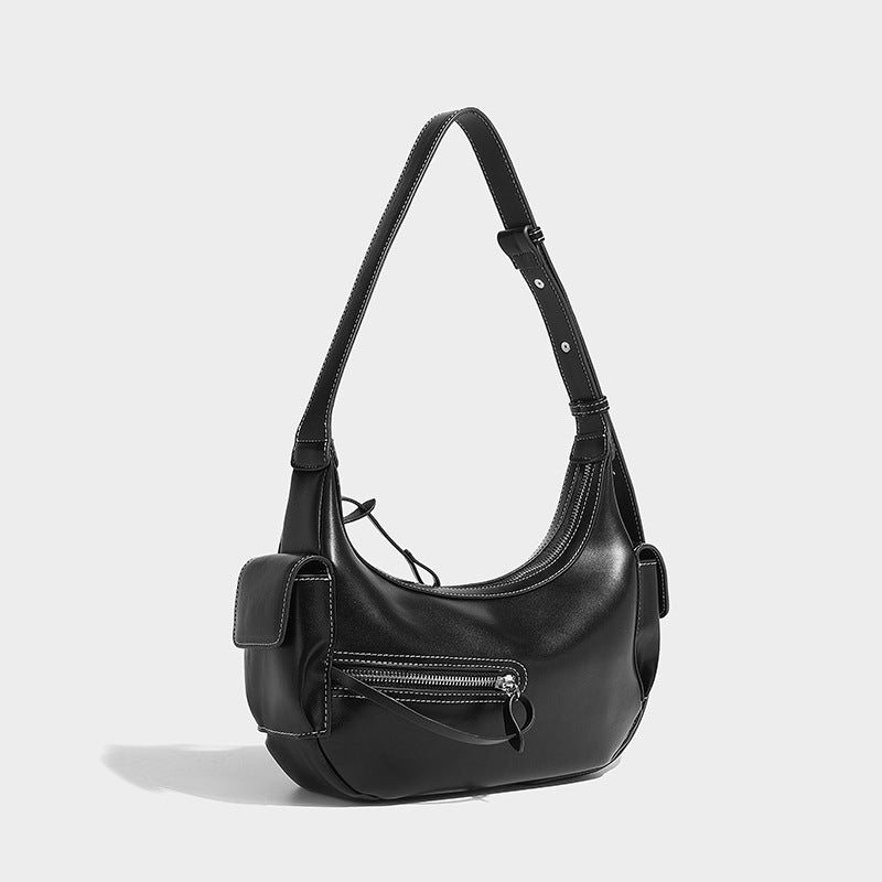 Smooth leather-look crescent shoulder bag with front zip pocket, side flap pockets, adjustable strap, and silver-tone, detail