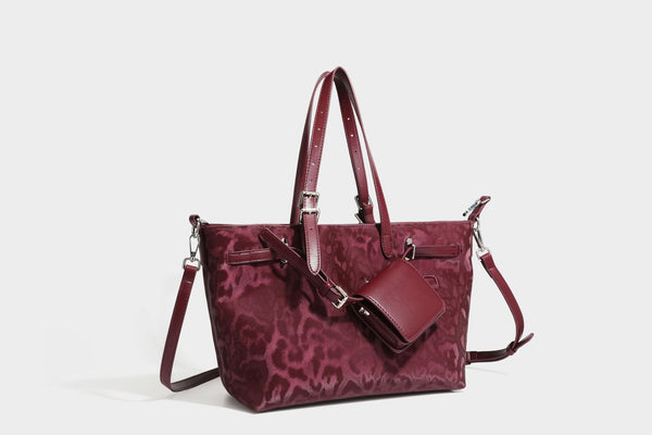 Glossy leopard-print tote bag with leather-look dark trim, dual top handles, detachable shoulder strap, and attached front