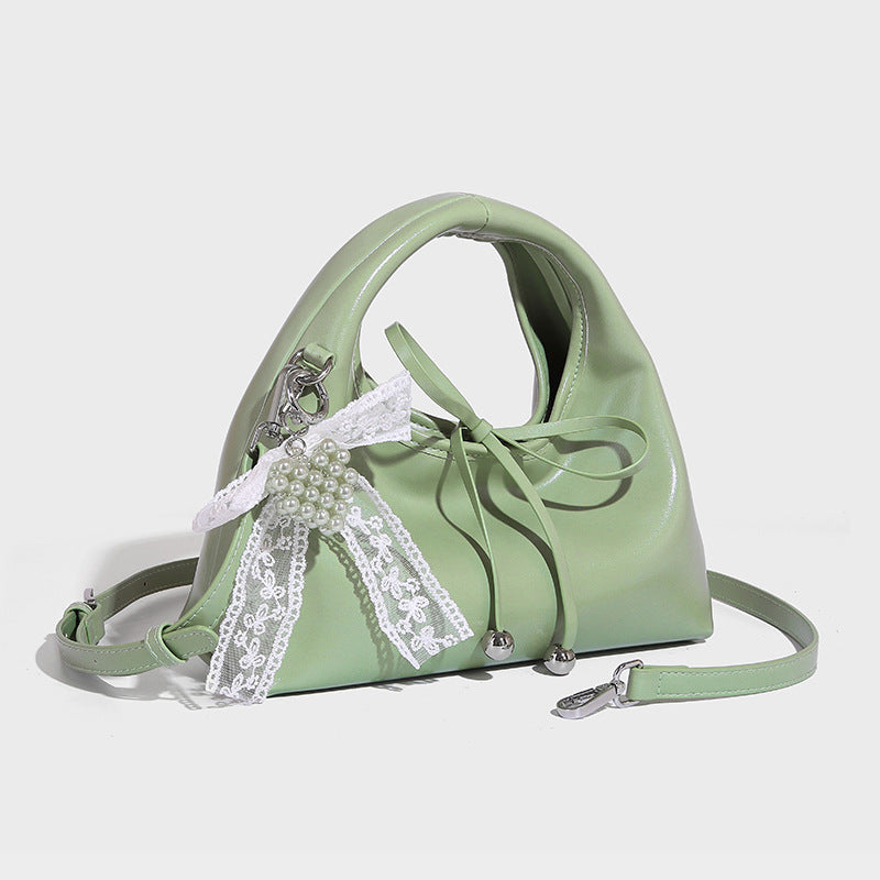 Kleine glänzende kuppelförmige Henkeltasche in Lederoptik mit Zugbandverschluss, weißem Spitzen-Schleifenanhänger und silberfarbenen Beschlägen