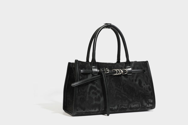 Structured leopard-print tote bag with glossy satin-like finish, dual rounded top handles, silver buckle-and-ring front