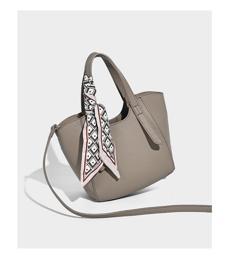 Structured pebbled leather-look tote bag with detachable scarf tie, dual top handles, and adjustable crossbody strap, detail