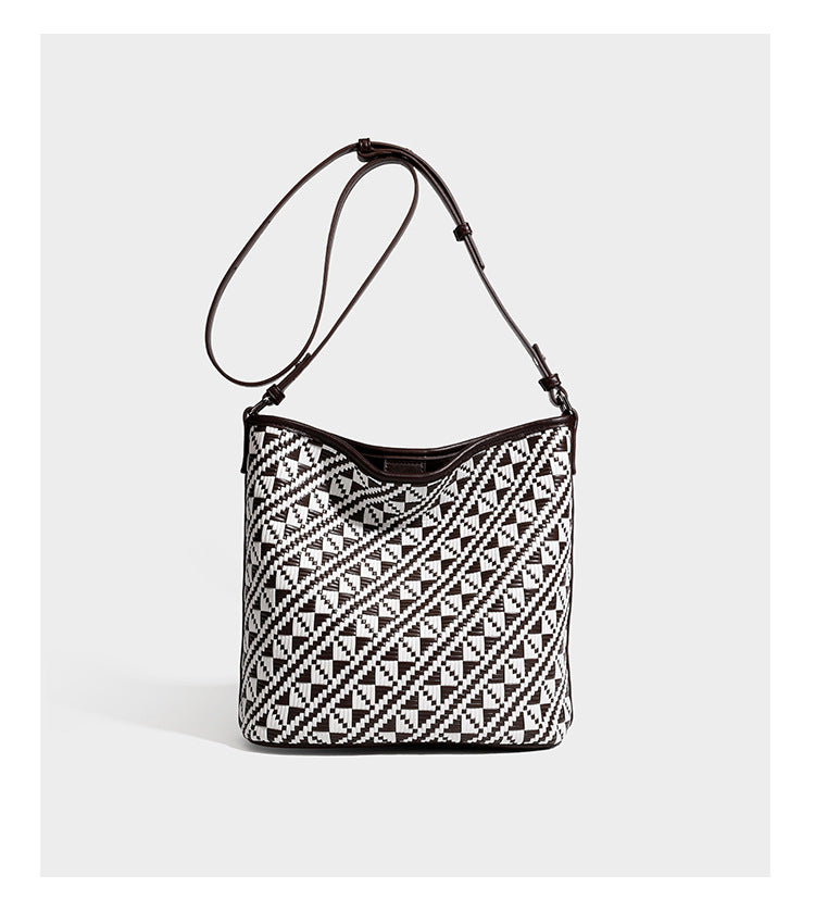 Geflochtene Schultertasche mit geometrischem Ethno-Muster, Besatz in dunkelbrauner Lederoptik, langem verstellbarem Träger und kleinem hängendem Reißverschluss