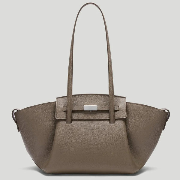 Black pebbled trapezoid tote bag with gold turn-lock hardware and double top handles, detail view 2