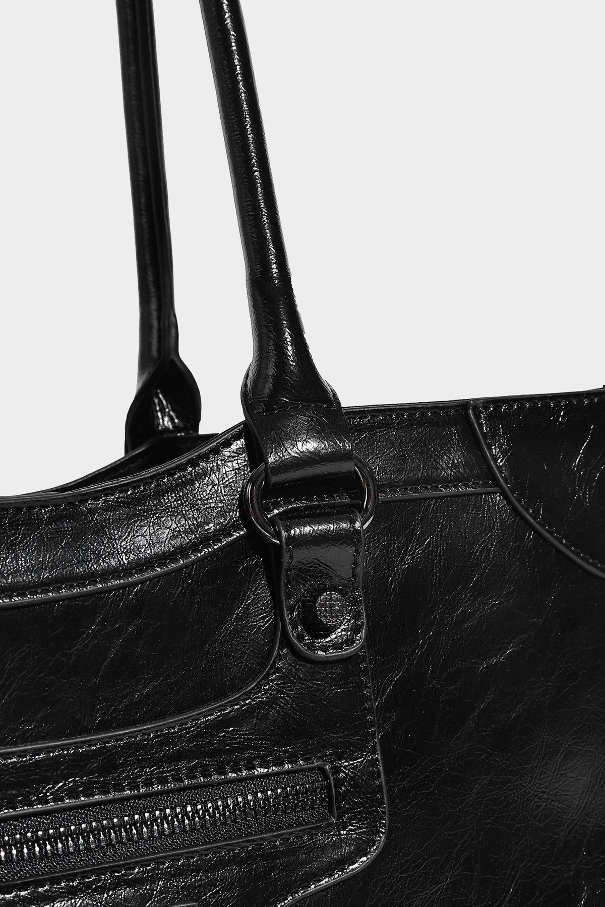 Large structured leather-look tote bag with front zip pocket, moto hardware accents, and long double shoulder straps, detail