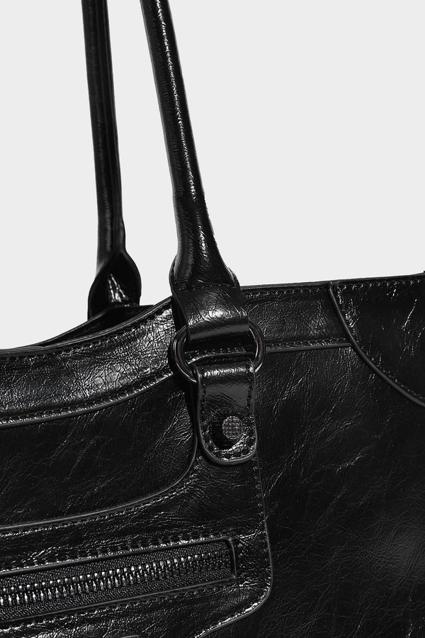 Large structured leather-look tote bag with front zip pocket, moto hardware accents, and long double shoulder straps, detail
