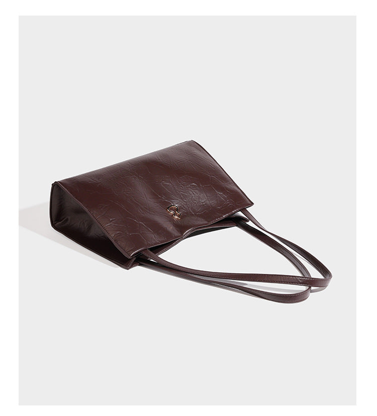 Strukturierte, rechteckige Tote-Schultertasche mit glänzender, geknautschter Lederoptik, langen Doppelriemen und goldfarbenem Emblem