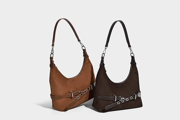 Hobo-Schultertasche in Dunkelbraun mit velourslederartiger Oberfläche, silberfarbener Gürtelschnalle und Ösenbeschlägen, verstellbarem Riemen, Detailansicht