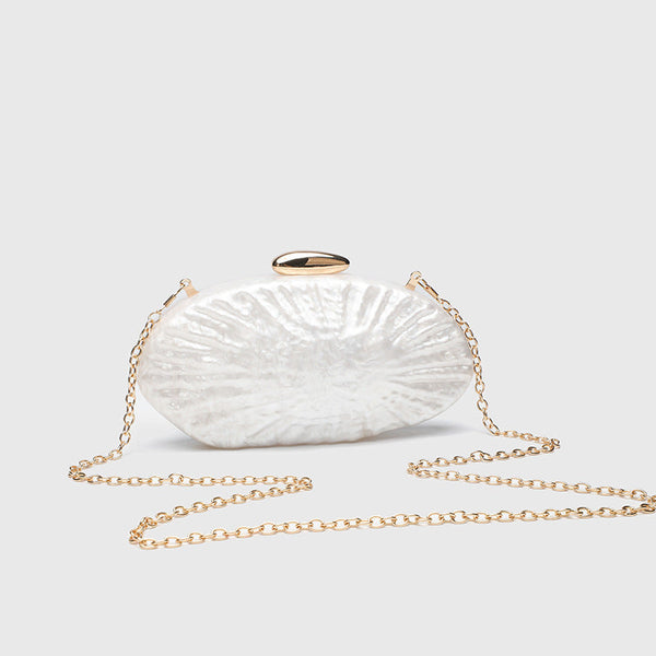 Oval pearl-finish shell clutch bag with gold-tone clasp and removable gold link chain strap, detail view 2