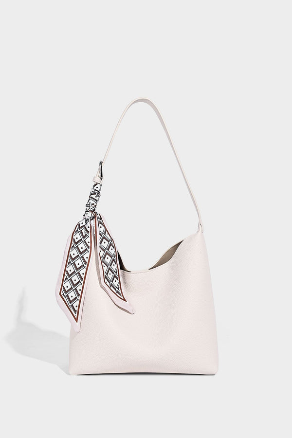 Soft slouchy hobo shoulder bag in pebbled matte finish with slim strap, silver-tone ring hardware, and knotted printed scarf